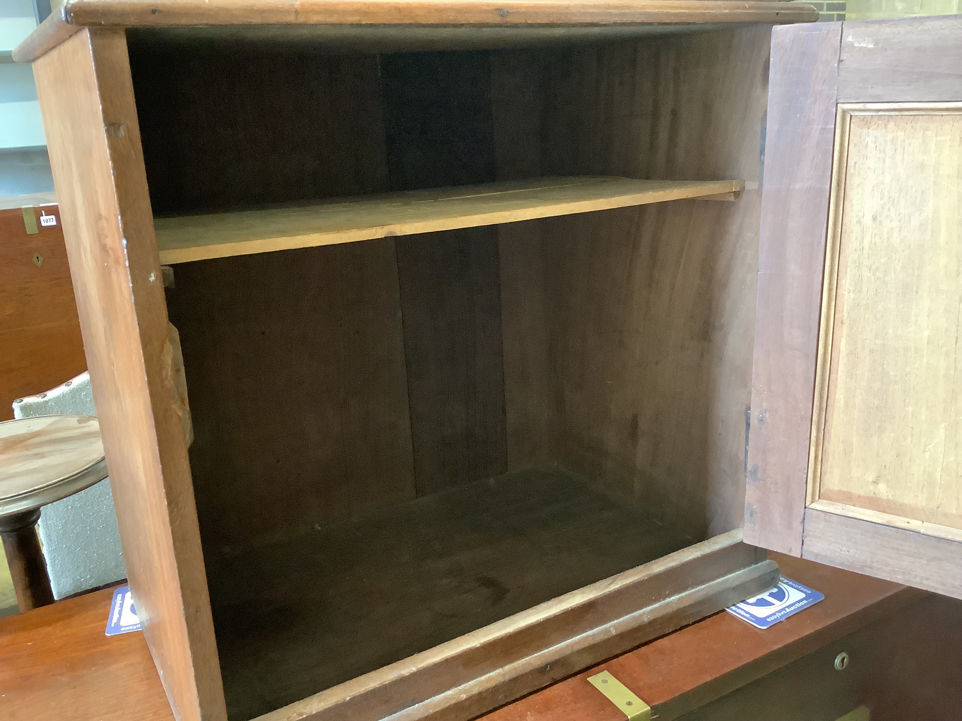 A Victorian mahogany cupboard, enclosed by a panelled door
